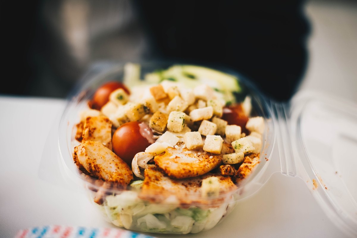 Bowl of salad with grilled chicken, cherry tomatoes and croutons