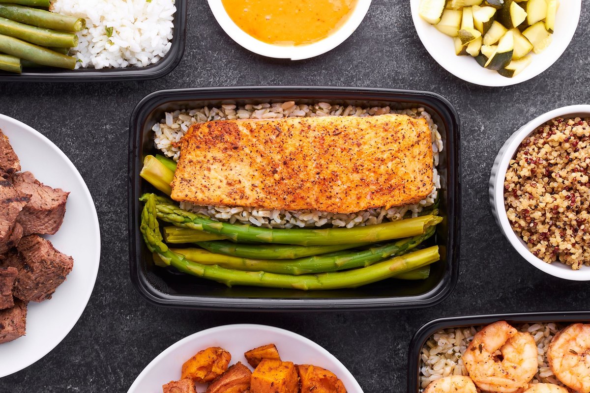 Overhead view of prepared meals with salmon, rice, asparagus, shrimp and sweet potato