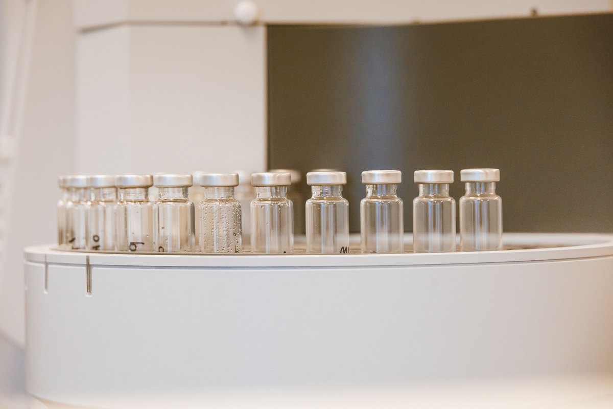 Row of small glass vials with silver caps on a laboratory instrument